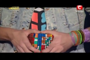 Парень очень быстро собирает большой кубик-рубик